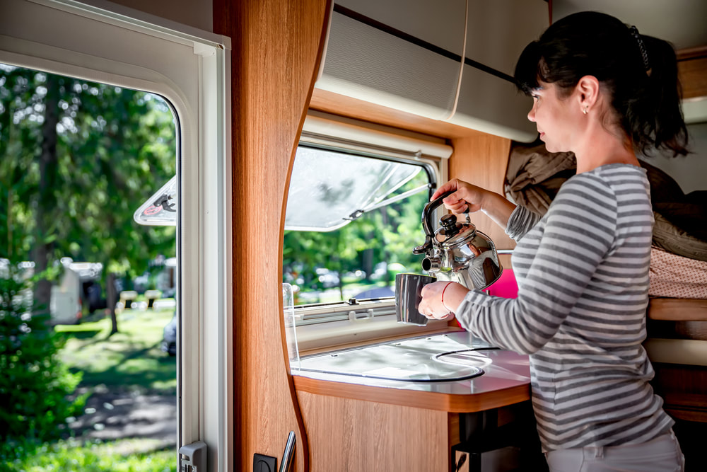 woman making a cup of tea inside her RV